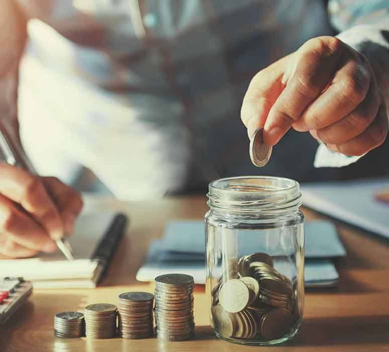 Someone putting coins in a jar