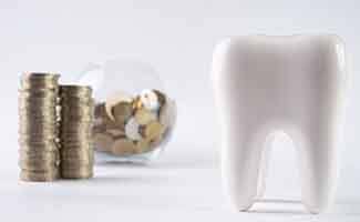 Tooth next to a pile of coins