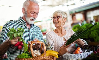 a couple shopping for vegetables at a farmer’s market