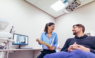 Dentist smiling at patient during consultation