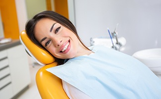 Woman smiling while sitting in treatment chair