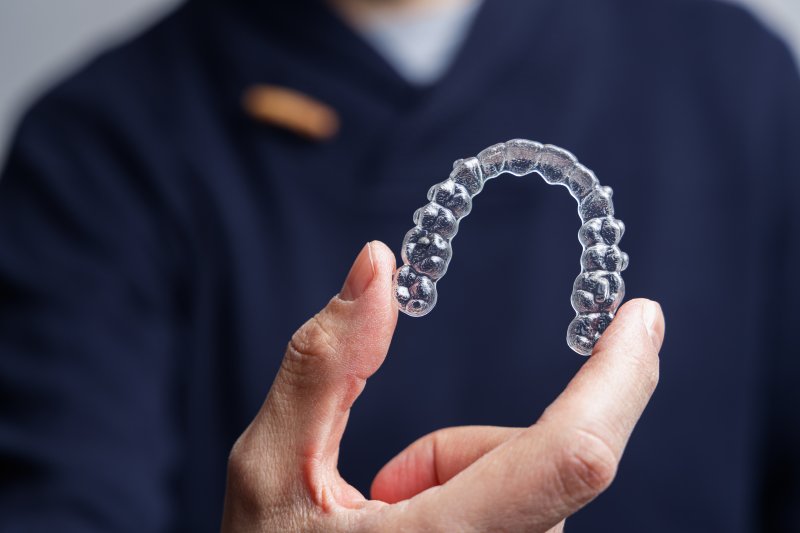 dentist holding an Invisalign aligner 